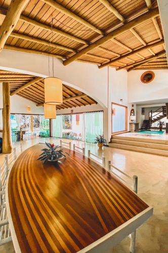 a large room with a wooden floor and a table at Paraíso Casa Branca in Arraial d'Ajuda