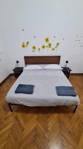 a bedroom with a bed with yellow flowers on the wall at Dock Bay Lodge Hostel in Trieste