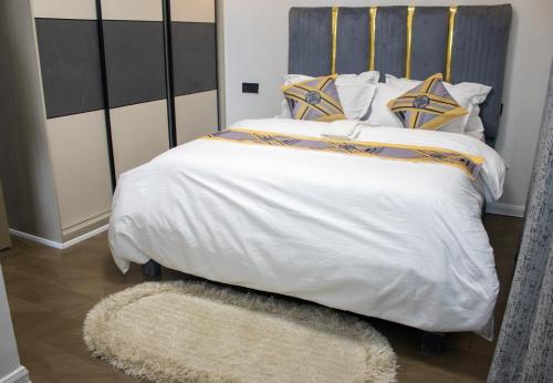a large bed with a white comforter and a rug at Jemmimah jkia homes in Nairobi