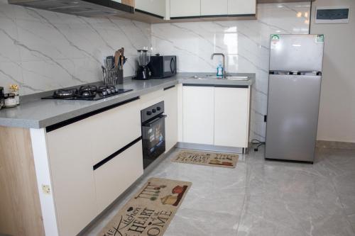 une cuisine avec une cuisinière et un réfrigérateur dans l'établissement Jemmimah jkia homes, à Nairobi