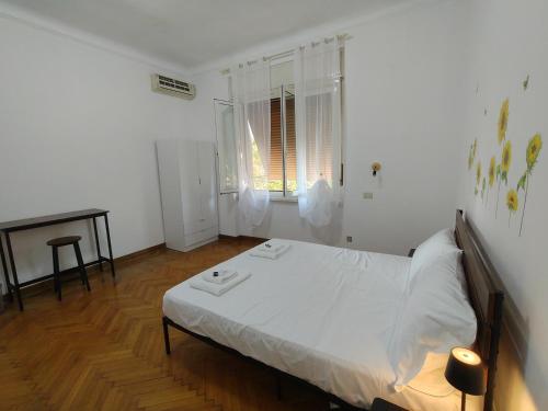 a bedroom with a white bed and a wooden floor at Dock Bay Lodge Hostel in Trieste