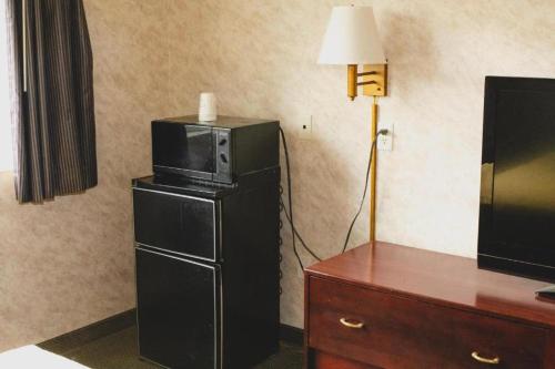 a room with a microwave on top of a refrigerator at Colfax Inn By Marifah in Colfax