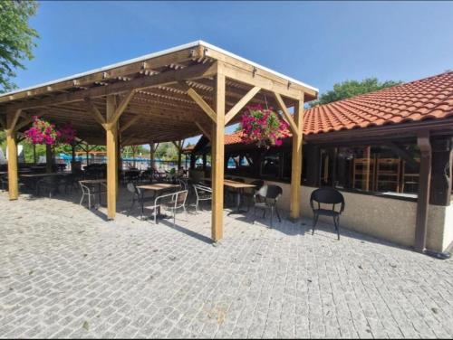 a pavilion with tables and chairs in a patio at Mobil home dans camping familial piscine in Sainte-Eulalie-en-Born