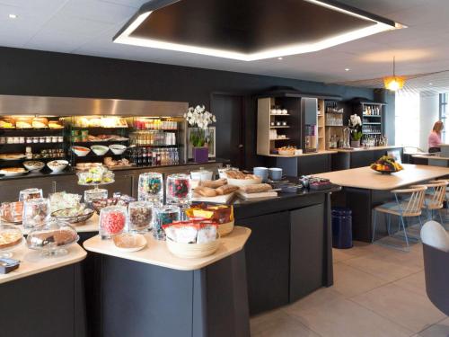 a restaurant with several tables with food on them at Novotel Suites Paris Montreuil Vincennes in Paris
