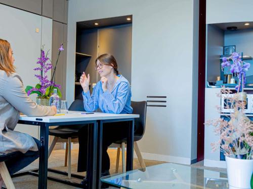 two women sitting at a table in a room at Novotel Suites Paris Montreuil Vincennes in Paris