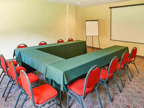 a conference room with a table and chairs and a whiteboard at Ibis Monterrey Aeropuerto in Monterrey