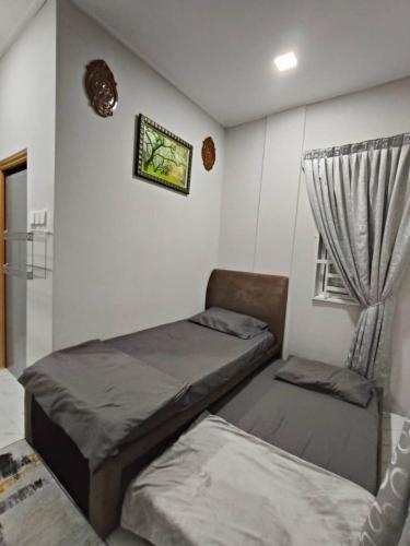 a bedroom with two beds and a window at Homestay and roomstay Din 5555 in Tumpat
