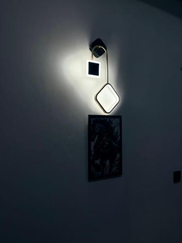 a light on a wall with a picture on it at Comfort Family Lodges in Islamabad