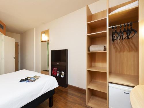 a room with a bed and a book shelf at Ibis São Carlos in São Carlos