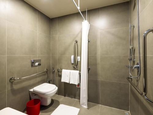 a bathroom with a toilet and a shower at Ibis São Carlos in São Carlos