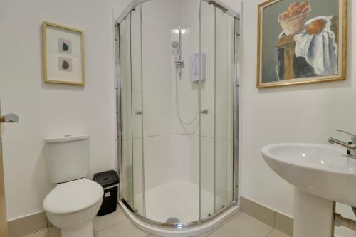 a bathroom with a shower and a toilet and a sink at Stylist Ground-Floor Studio Near City Centre in Portsmouth