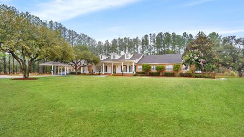 a house with a large yard in front of it at Tranquil 1 BR Studio in Grand Bay - Oak & Fountain in Grand Bay