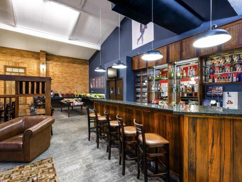 a bar with a row of stools in a restaurant at Ibis São Carlos in São Carlos