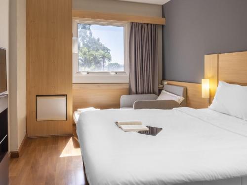 a hotel room with a large bed and a window at ibis Sao Jose do Rio Preto in Sao Jose do Rio Preto