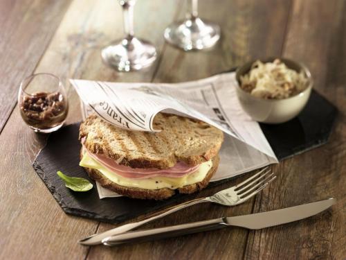 a sandwich on a black plate on a wooden table at ibis Sao Jose do Rio Preto in Sao Jose do Rio Preto