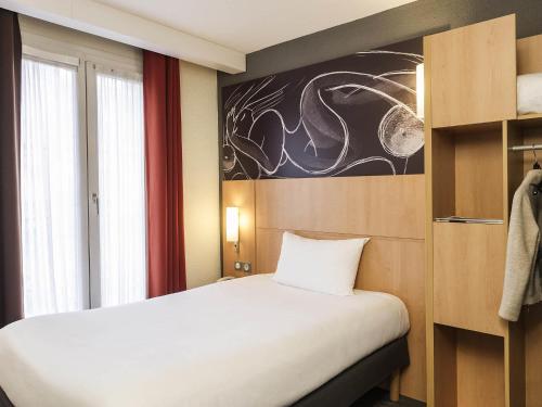 a bedroom with a white bed and a window at ibis Paris Vaugirard Porte de Versailles in Paris