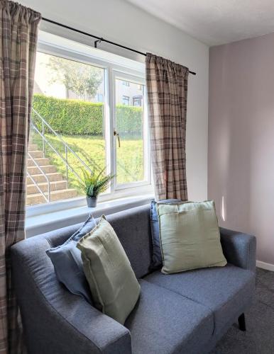 a blue couch in a living room with a window at Kintyre House in Campbeltown