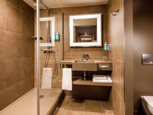 a bathroom with a sink and a shower at Novotel London Bridge in London