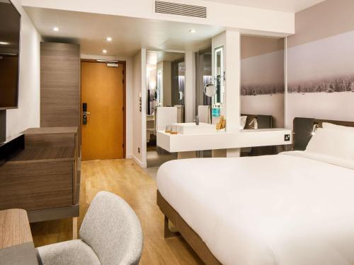 a hotel room with a bed and a bathroom at Novotel London Bridge in London