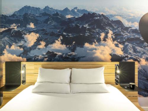 a bedroom with a mountain mural on the wall at Novotel Leeds Centre in Leeds