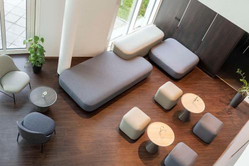 a living room with two tables and two chairs at NH München Airport in Oberding