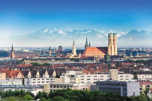 a view of a city with mountains in the background at NH München Airport in Oberding