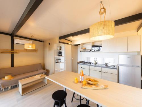 a kitchen and living room with a table and a couch at Vigna Maggiore in Olmeto