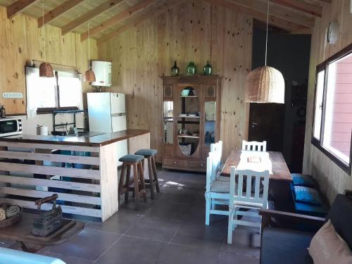 Una cocina y un comedor con mesa y sillas. en Cabaña Sueca, en Mar del Plata