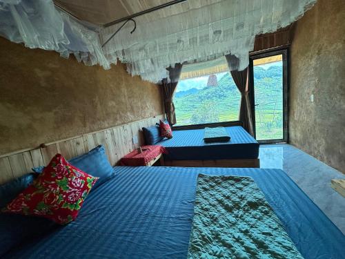 a bedroom with two beds and a window at Kiên Mán Homestay in Ha Giang