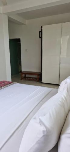 a bedroom with a white bed and an open door at Amara White Villa in Ahungalla