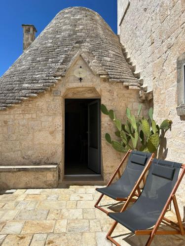 two chairs sitting in front of a building at iCONICO - Authentic Trulli Experience in Cisternino