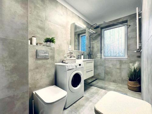 a bathroom with a washing machine and a toilet at Na Fali 4 Aquapark Reda in Rumia