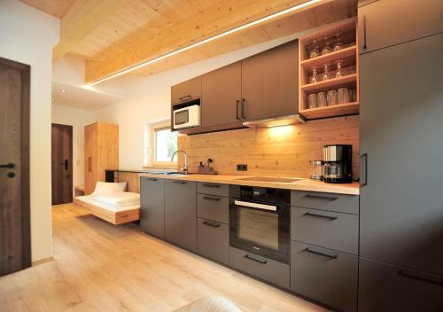 a kitchen with stainless steel appliances and wooden ceilings at Hotel Galtürerhof in Galtür