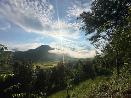a view of a mountain with the sun in the sky at Kiên Mán Homestay in Ha Giang