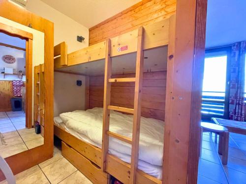ein Schlafzimmer mit einem Etagenbett in einem Zimmer in der Unterkunft Grand studio pour 4, Les Menuires, aux pieds des pistes - FR-1-452-397 in Les Menuires