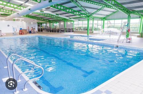 a large swimming pool with blue water in a building at The Mayflower in Skipsea