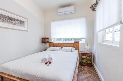 une chambre avec un lit avec des draps blancs et une fenêtre dans l'établissement Luxury boutique apartment in best location, à Tel Aviv
