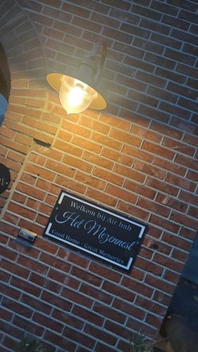 a sign on a brick wall with a surfboard on it at Het Mezennest in Zonhoven
