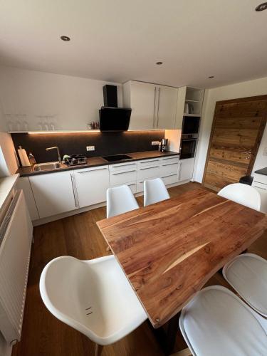 a kitchen with a wooden table and white chairs at Ferienwohnung Prutz Tullenweg 17 Oberinntal Tirol in Prutz