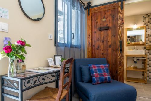 a room with a desk and a blue chair and a table at La Ferme De Mon Grand-père in Saint-Pons