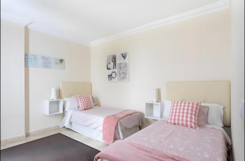 El GuinchoにあるApartamento Rolycar 102のベッド2台と鏡のある寝室