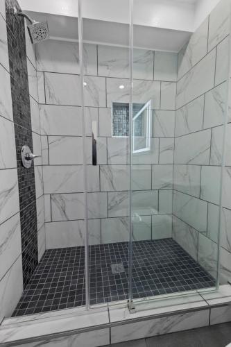 eine Dusche mit Glastür im Badezimmer in der Unterkunft Downey Inn in Downey