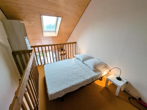 a small bedroom with a bed in a attic at Séjour au calme -Maison 1 chambre pour 4 personnes - Plage à pied in Le Pouliguen