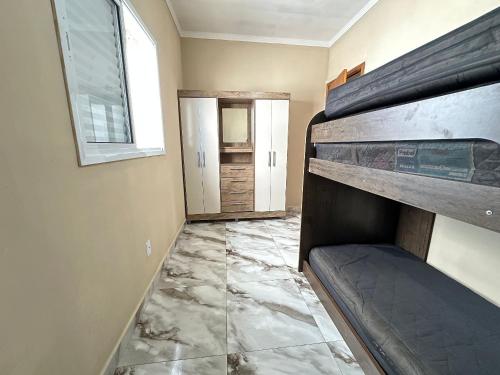 een kamer met een marmeren vloer en een raam bij Estadia no Caiçara com Praia a 150m! in Vila Balneária