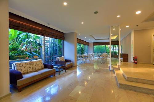 a living room with couches and a table and chairs at Perle Apart Hotel in Alanya