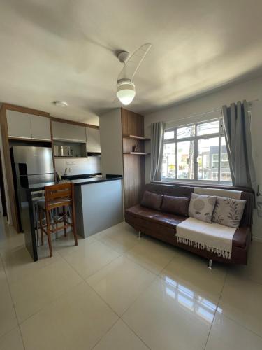 a living room with a couch and a kitchen at Residencial Nicole in Florianópolis
