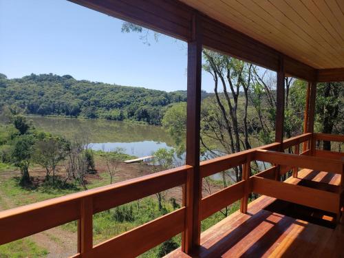 a view of a lake from the porch of a cabin at Casa rústica às margens do lago in Maximiliano de Almeida