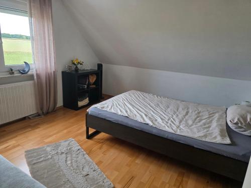 a bedroom with a bed and a window at Querenhorst, Unterkunft am Feld in Querenhorst