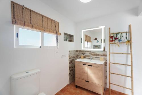 ein Badezimmer mit Waschbecken, Toilette und Spiegel in der Unterkunft Finca Pisaverde, a peaceful haven between the sea and Teide in El Pris
