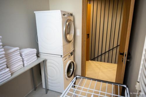 a laundry room with a washer and dryer next to a door at Aura dom na wynajem in Jeziorki